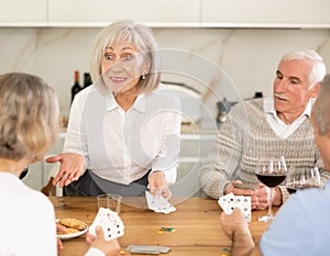 Couples of elderly women and men playing poker