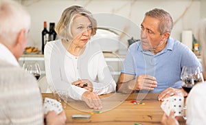 Couples of elderly women and men playing poker