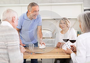 Couples of elderly women and men playing poker