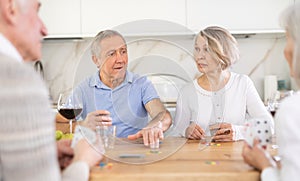 Couples of elderly women and men playing poker