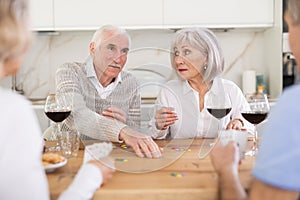 Couples of elderly women and men playing poker