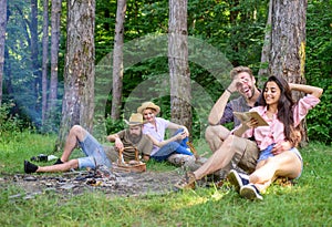 Couples or families having great time relaxing near campfire. Couples spend time outdoors on sunny day. Youth on picnic