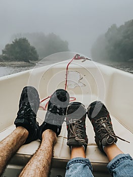 Couples feet in a boat on a foggy morning