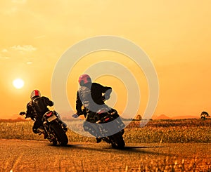 couples friend motorcycle rider biking on asphalt highway against beautiful sun set sky use for people and man leisure activities photo