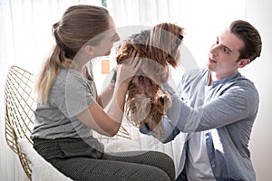 Couples are having fun with their dogs in the living room in the house.