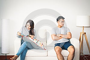 Couples just married, quarrel, refuse to talk to each other. Both sit on the sofa photo
