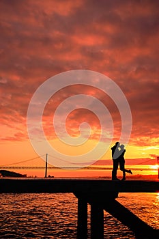 Couples kissing on the bridge at sunset