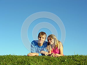 Couples lie on grass