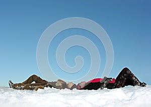 Couples lies on snow and watch up