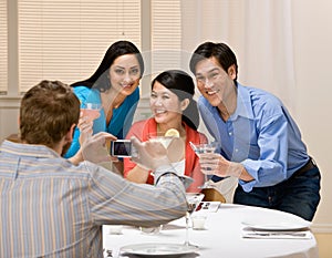 Couples posing for photograph at dinner party