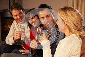 Couples Sitting On Sofa With Champagne