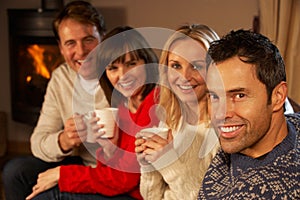 Couples Sitting On Sofa With Hot Drinks Talking