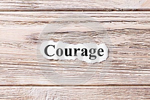 COURAGE of the word on paper. concept. Words of COURAGE on a wooden background