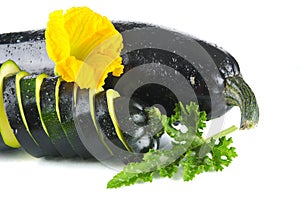 Courgette cut into slices and leaves on white