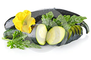 Courgettes cut into slices with flower and leaves on white