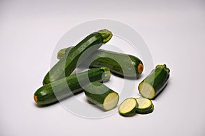 Whole and sliced courgettes on a seamless background