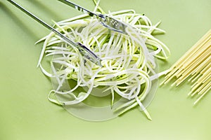 Courgetti and spaghetti on green chopping board