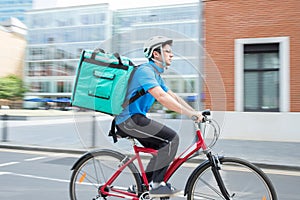 Courier On Bicycle Delivering Food In City photo