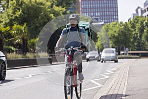 Courier On Bike Delivering Takeaway Food In City