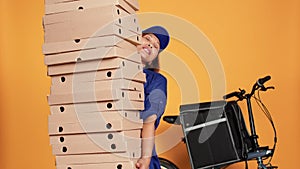 Courier burdened by huge pile of pizza