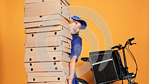 Courier burdened by huge pile of pizza photo