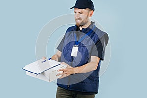 Courier delivering box, offering to sign a paper form, that lies on top of box.