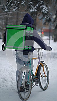 Courier is delivering food with backpack at winter
