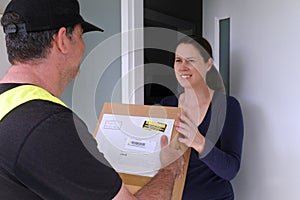 Courier delivering package box to a woman at home