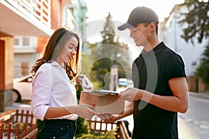 Courier Delivering Package To Woman. Client Receiving Box