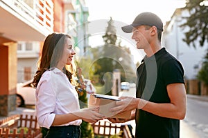 Courier Delivering Package To Woman. Client Receiving Box