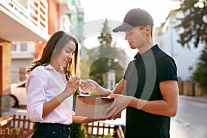 Courier Delivering Package To Woman, Client Signing Document