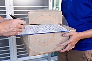 Courier delivery man checking or holding cardboard parcel package to deliver to client for accepting a delivery of boxes