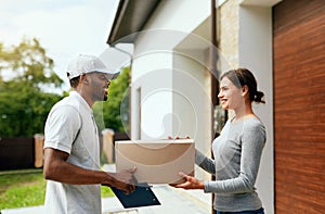 Courier Delivery. Man Delivering Package To Woman At Home