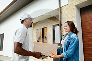 Courier Delivery. Man Delivering Package To Woman At Home