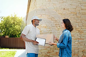 Courier Delivery. Man Delivering Package To Woman At Home