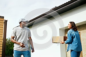 Courier Delivery. Man Delivering Package To Woman At Home