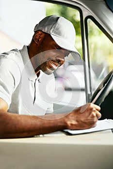 Courier. Delivery Man Reading Addresses Sitting In Delivery Van