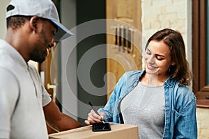 Courier Delivery Service. Man Delivering Package To Woman