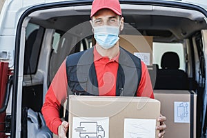 Courier driver man delivering package while wearing safety mask - Focus on face