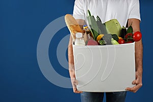 Courier with fresh products on background, closeup. Food delivery service