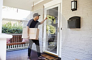 Courier Knocking On Door Of House To Deliver Package