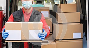 Courier man delivering package in front of cargo truck with face mask - Focus on face