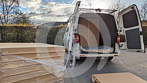 A courier picking up box parcels from a delivery depot warehouse