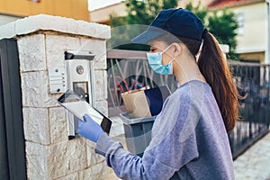 Courier`s hands in medical gloves deliver parcels to the door during the epidemic coronovirus, COVID-19.