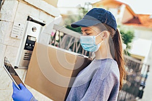 Courier`s hands in medical gloves deliver parcels to the door during the epidemic coronovirus, COVID-19.