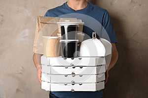 Courier with stack of orders on beige background.