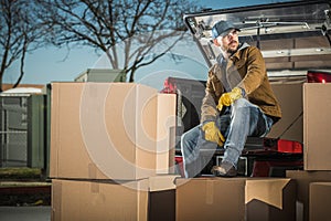 Courier Unloading Shipping Boxes Parcel From His Truck