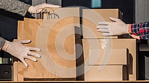 Couriers in protective gloves put parcels on the doorstep of the house