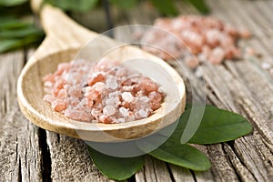 Course pink Himalayan salt on a wooden spoon photo