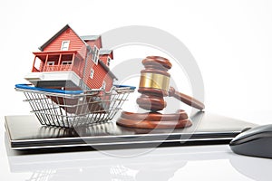 court hammer and auction on the background of a house model in a grocery basket and a laptop. legitimacy of real estate